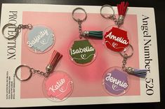 four different key chains with names on them sitting on top of a piece of paper