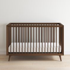 an empty crib in a room with white walls