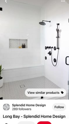 a white tiled bathroom with black fixtures and shower head mounted on the wall above the bathtub