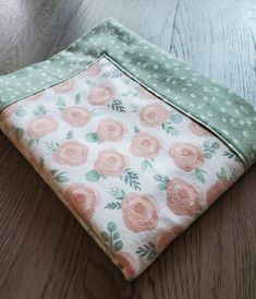 a close up of a cloth with flowers on it sitting on a wooden table top