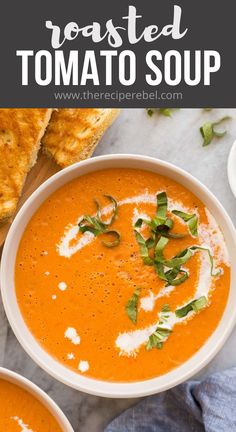 two bowls of tomato soup with bread and herbs