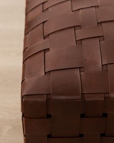 a close up of a brown leather bench with woven design on the seat and back