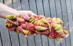 a person holding out their hand with some kind of yarn on it