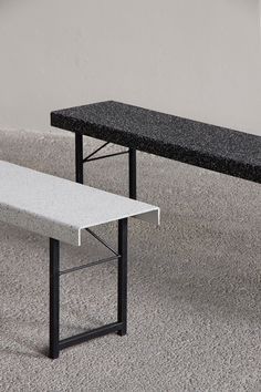 two black and white benches sitting on top of a carpeted floor next to each other