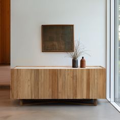 a wooden cabinet with two vases on it