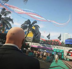 a man in a suit looking at some jets flying over him and on his head