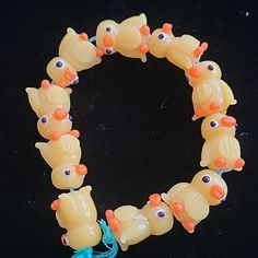 a bracelet made out of plastic beads with orange and blue fish on it's sides