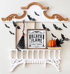 a white shelf with some black bats on it and a sign that says it's october witches