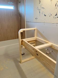 an unfinished bed frame in the corner of a room with white walls and flooring