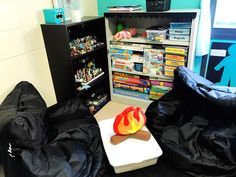 a room filled with black bean bags and bookshelves full of games on shelves