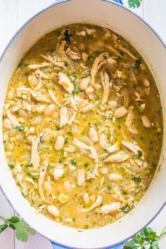 chicken and white bean soup in a blue pot with parsley on the side, ready to be eaten