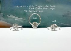 three silver rings sitting on top of a white table next to each other with measurements for them