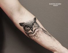 an owl tattoo on the left arm