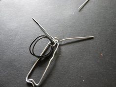 a pair of scissors sitting on top of a piece of paper with wire attached to it