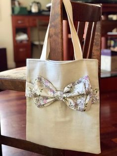 a bag with a bow on it sitting on top of a wooden chair in front of a table