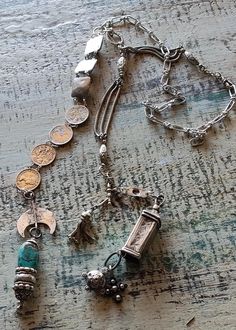 An assemblage of a Victorian silver Albertina watch chain. Silver vintage British coming from a bracelet, silver plated antique Art Deco elements from a British box chain necklace, an ethnic Berber silver element from a fibula with two silver Moroccan charms. The other end of the lariat features a silver crescent moon with niello either from Morocco or Tunisia supporting a large Hubei mine turquoise, a silver tubular bead from an old Omani necklace and a Bali silver bead strung on Rajasthani silver post with silver ball charms. Has a toggle clasp so you can adjust how you wear it. Vintage Jewelry Display, Silver Element, Vintage Assemblage Necklace, Junk Jewellery, Altered Art Jewelry, Jewelry Assemblage, Art Deco Elements, 2024 Jewelry, Vintage Assemblage Jewelry