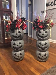 two cement pumpkin vases sitting on top of a wooden floor