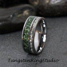 a wedding band with green moss inlays and white diamonds on the inside of it