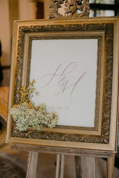 a wooden easer holding a sign with flowers on it