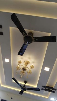 a ceiling fan and chandelier in a room with lights on the ceiling above it