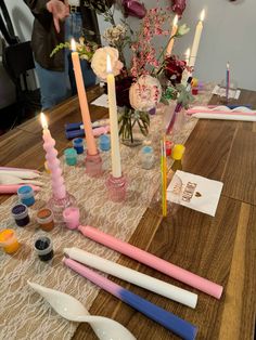 a table topped with lots of different types of candles and spoons next to each other