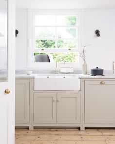 a white kitchen sink sitting under a window