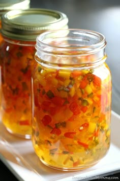 three jars filled with pickled vegetables on top of a white plate