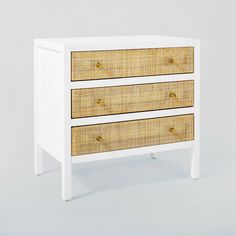 a white and wicker dresser with three drawers