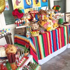 an assortment of desserts and sweets displayed on a table at a mexican themed birthday party