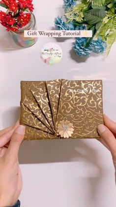 a person holding up a gold gift wrapper