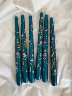 Dark teal dinner candles are hand painted with gold moons and pretty pink and ochre flowers. How To Paint Candles Tutorials, How To Paint Candles Diy, Painted Candles Diy, Quirky Candles, Teal Candles, Candle Making Studio, Pretty Candles