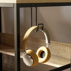 headphones hanging from the side of a shelf