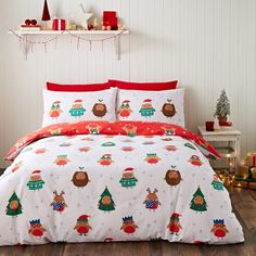 a bed with christmas themed sheets and pillows