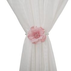 a white curtain with a pink flower attached to the back of it's drapes