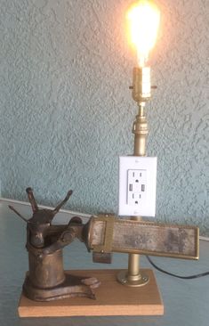 a light that is on top of a wooden stand next to a plug in the wall