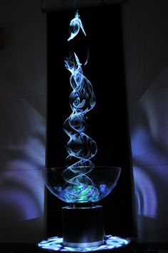 a glass bowl that is sitting on top of a table in front of a black background