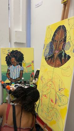 a woman sitting in front of two paintings on easels with her back to the camera