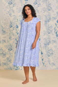 This soft waltz gown is designed with Tencel Modal jersey in a sweet blue floral print. It features a sweetheart neckline trimmed with vertical pintucks and edge lace, floral pattern lace and vertical pintucks on the front yoke, edge lace-trimmed cap sleeves and a placket of flower-shaped Akoya shell buttons. It is finished with a ruffled hemline. Style Number: E60041-462 42" HPS Length Button Front Placket perfect for Nursing Mothers Tencel™ 95% Modal/ 5% Spandex Jersey Knit Model is wearing Si Eileen West, Nursing Mother, Queen Annes Lace, Shell Buttons, Blue Floral Print, Waltz, Pin Tucks, Flower Shape, Cap Sleeve