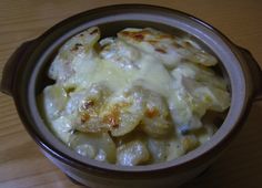 a bowl filled with macaroni and cheese on top of a wooden table