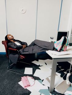 a man laying on top of a chair in an office