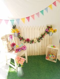 a room decorated with flowers and bunting on the wall for an easter party or baby's first birthday