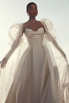 a woman in a white gown and cape