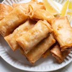 some food on a white plate with lemon wedges