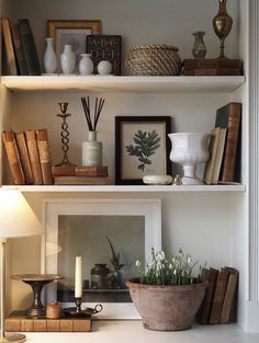 the shelves are filled with books and vases