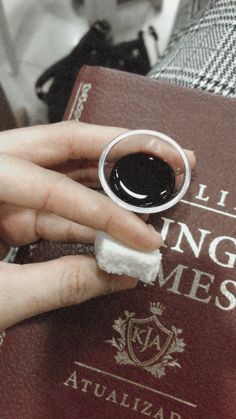 a person holding onto a book with a ring on it