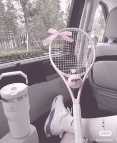 there is a tennis racket in the back seat of a car with pink bows on it