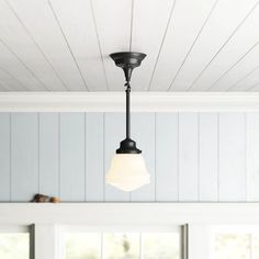 a light fixture hanging from the ceiling in a room with white walls and wood paneling