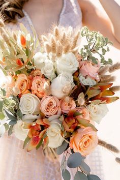 a bridal holding a bouquet of flowers and feathers in it's hands,