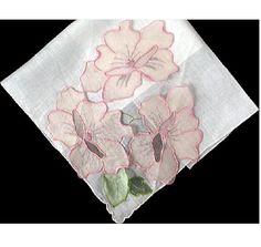 three pink flowers are on top of a white napkin