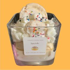 a container filled with ice cream and sprinkles on top of a yellow background